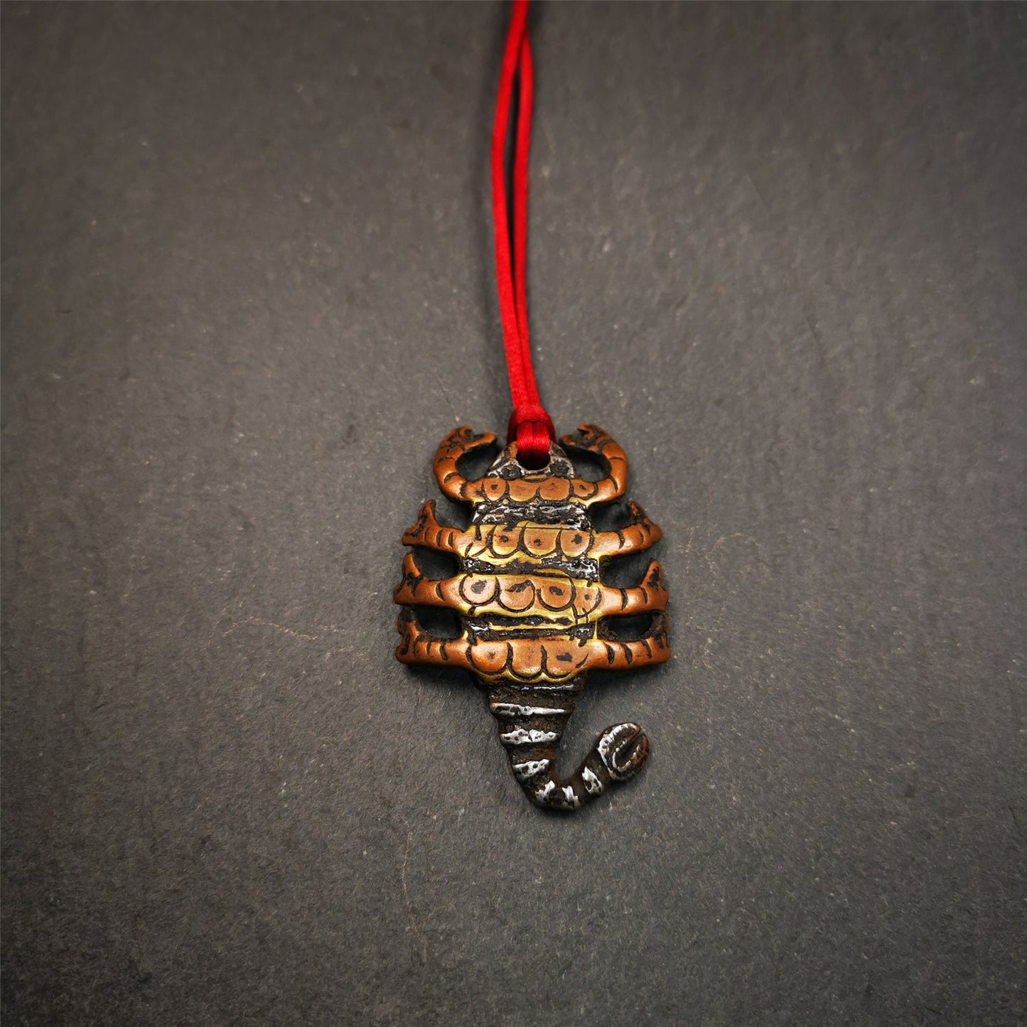 This scorpion amulet is made by Tibetan craftsmen in Hepo Township, Baiyu County, the birthplace of the famous Tibetan handicrafts. It is made of cold iron and copper,black color, size is 1.6 × 1.2 inches.The body is cold iron,and the legs are copper wire. You can make it into a necklace, or a keychain, or just put it in your shrine.