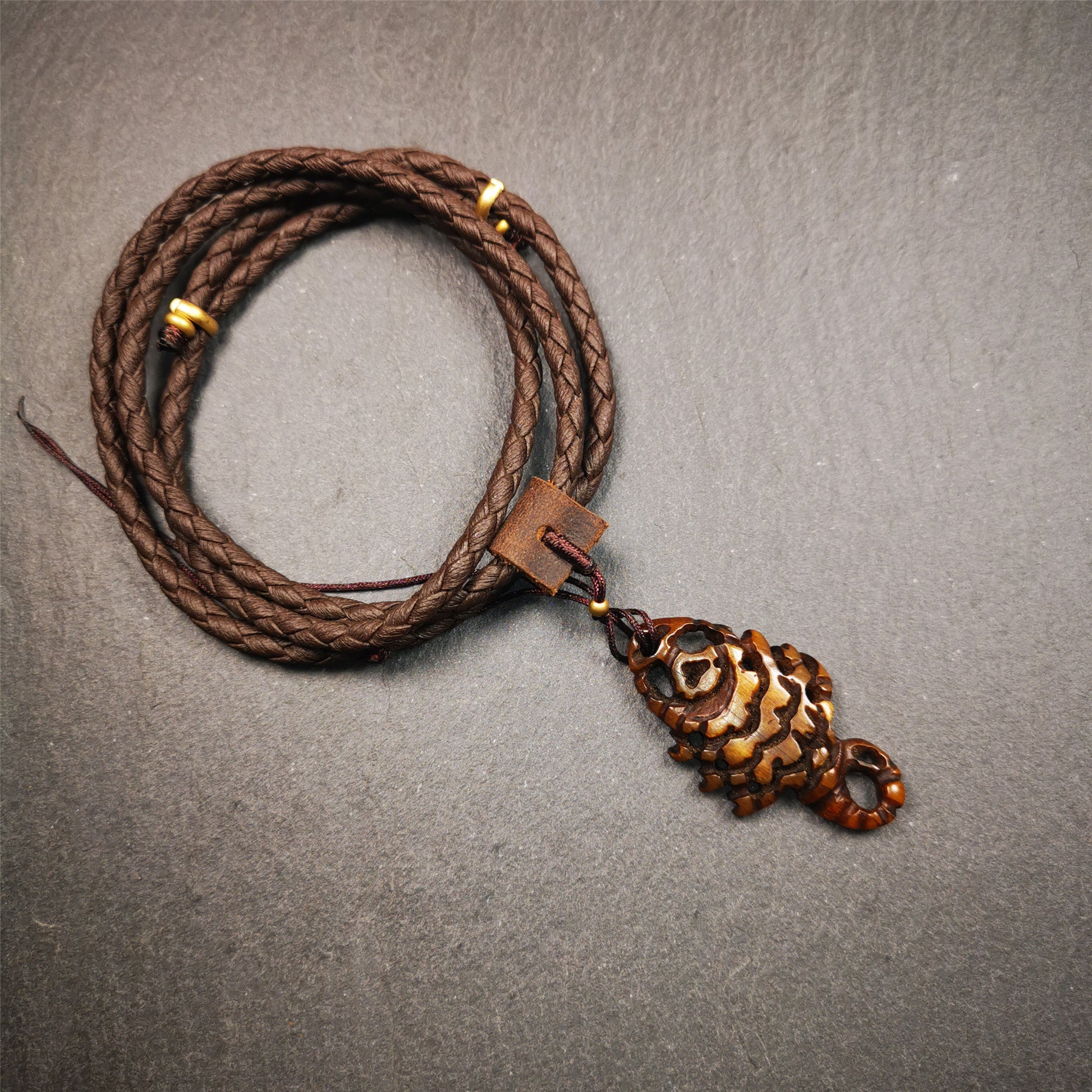 This unique bone carved Scorpion Guru pendant is made by Tibetan craftsmen in Hepo Township, Baiyu County, the birthplace of the famous Tibetan handicrafts. It's carved yak bone,brown color,1.77 inch height. You can make it into necklace.