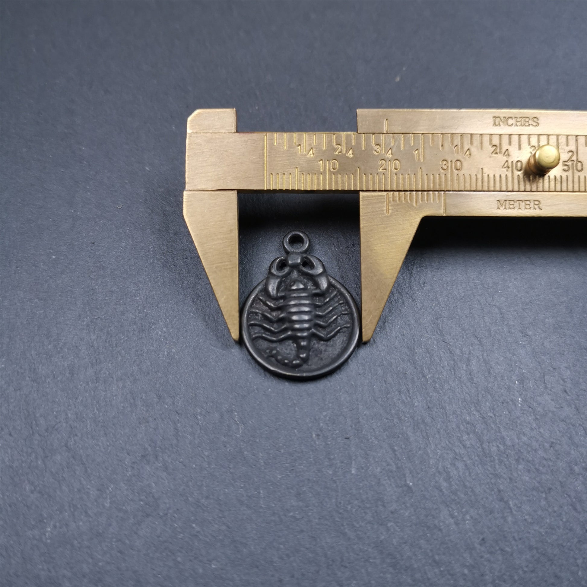 This scorpion amulet is made by Tibetan craftsmen in Hepo Township, Baiyu County, the birthplace of the famous Tibetan handicrafts. It is made of thokcha, size is 0.8 inches. You can make it into a necklace, or a keychain, or just put it in your shrine.