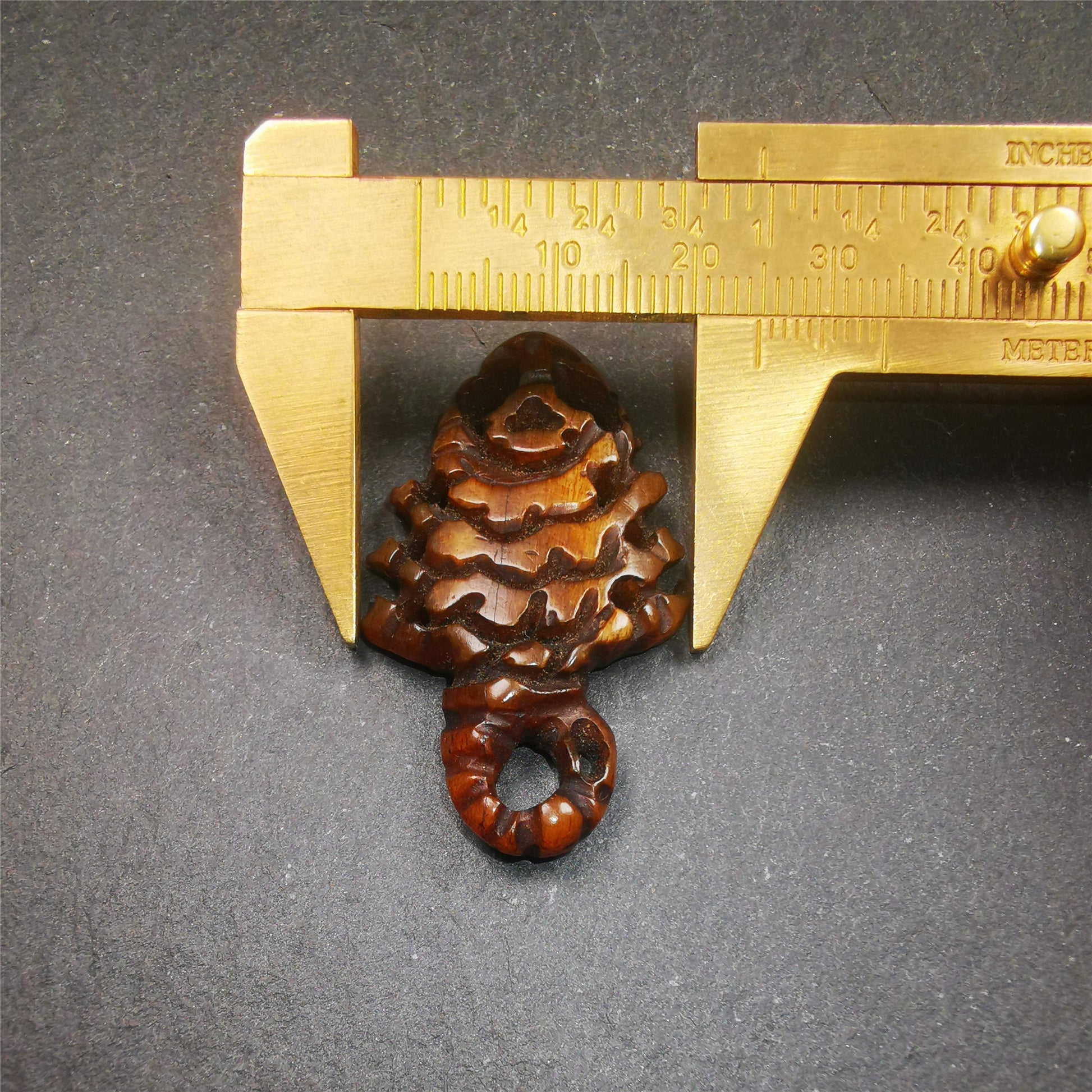 This unique bone carved Scorpion Guru pendant is made by Tibetan craftsmen in Hepo Township, Baiyu County, the birthplace of the famous Tibetan handicrafts. It's carved yak bone,brown color,1.77 inch height. You can make it into necklace.