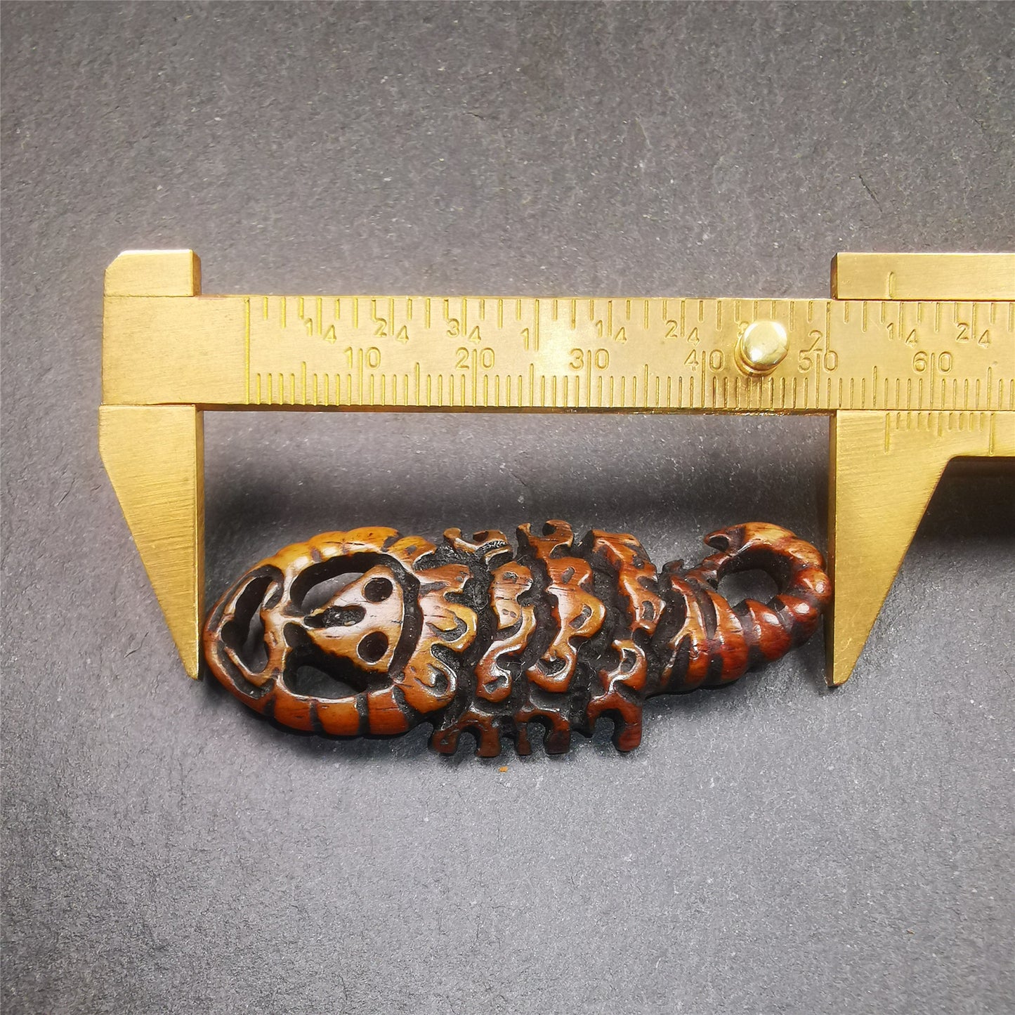 This unique bone carved Scorpion Guru pendant is made by Tibetan craftsmen in Hepo Township, Baiyu County, the birthplace of the famous Tibetan handicrafts. It's carved yak bone,brown color,2.2 inch height. You can make it into necklace,or mala pendant.