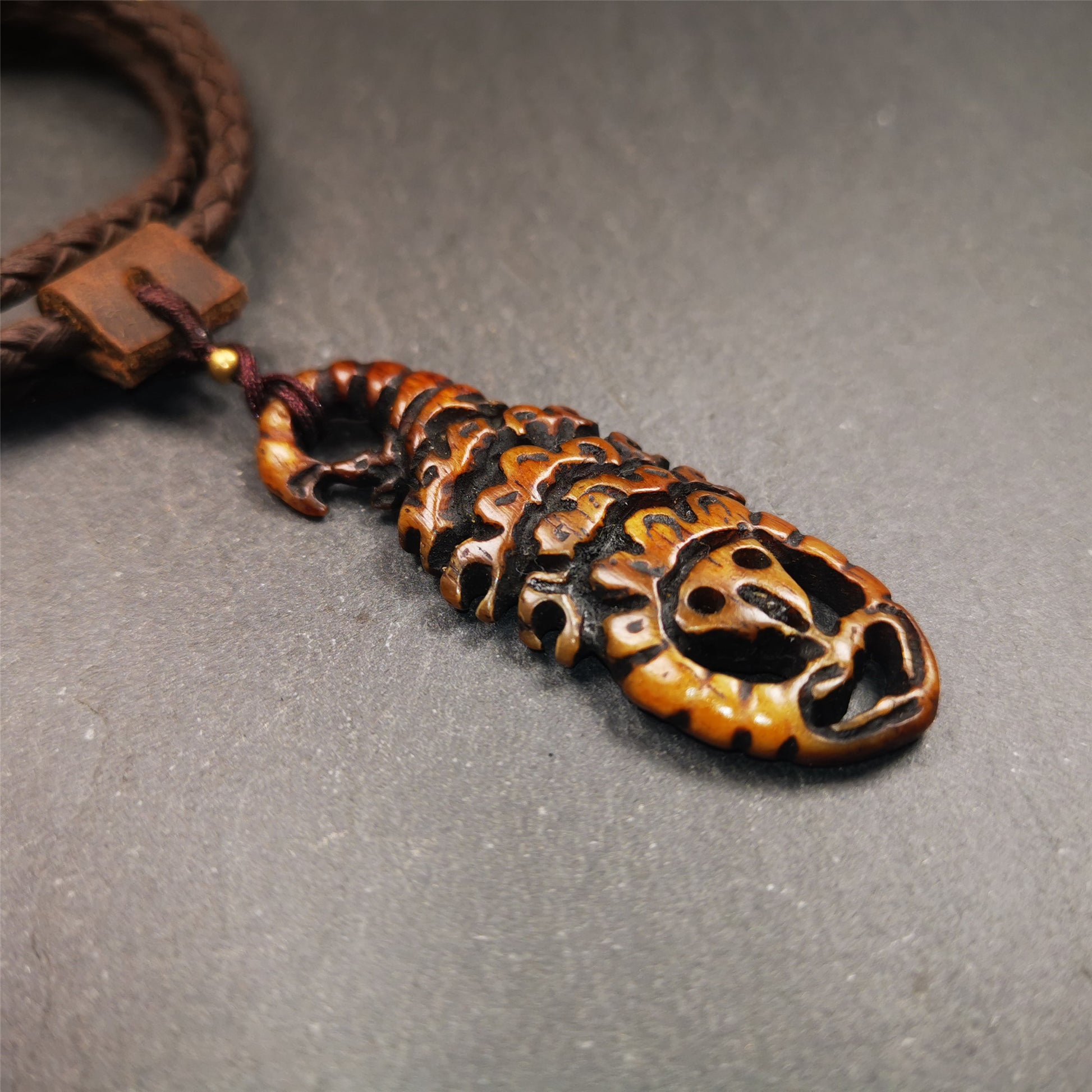 This unique bone carved Scorpion Guru pendant is made by Tibetan craftsmen in Hepo Township, Baiyu County, the birthplace of the famous Tibetan handicrafts. It's carved yak bone,brown color,2.2 inch height. You can make it into necklace,or mala pendant.