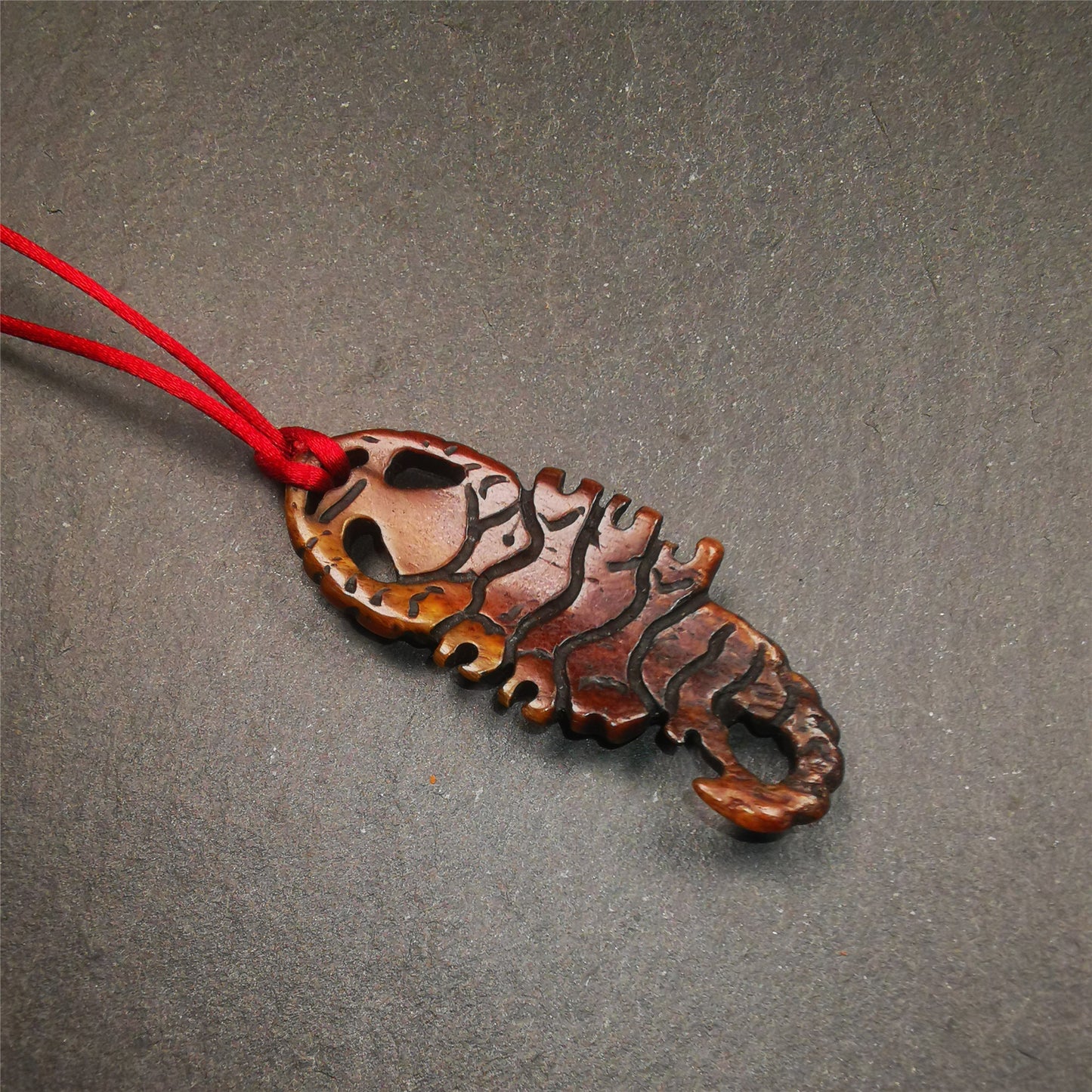 This unique bone carved Scorpion Guru pendant is made by Tibetan craftsmen in Hepo Township, Baiyu County, the birthplace of the famous Tibetan handicrafts. It's carved yak bone,brown color,2.2 inch height. You can make it into necklace,or mala pendant.