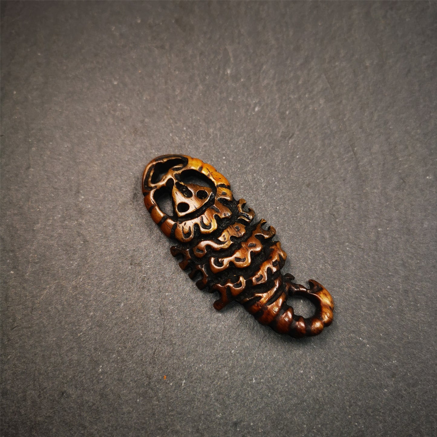 This unique bone carved Scorpion Guru pendant is made by Tibetan craftsmen in Hepo Township, Baiyu County, the birthplace of the famous Tibetan handicrafts. It's carved yak bone,brown color,2.2 inch height. You can make it into necklace,or mala pendant.