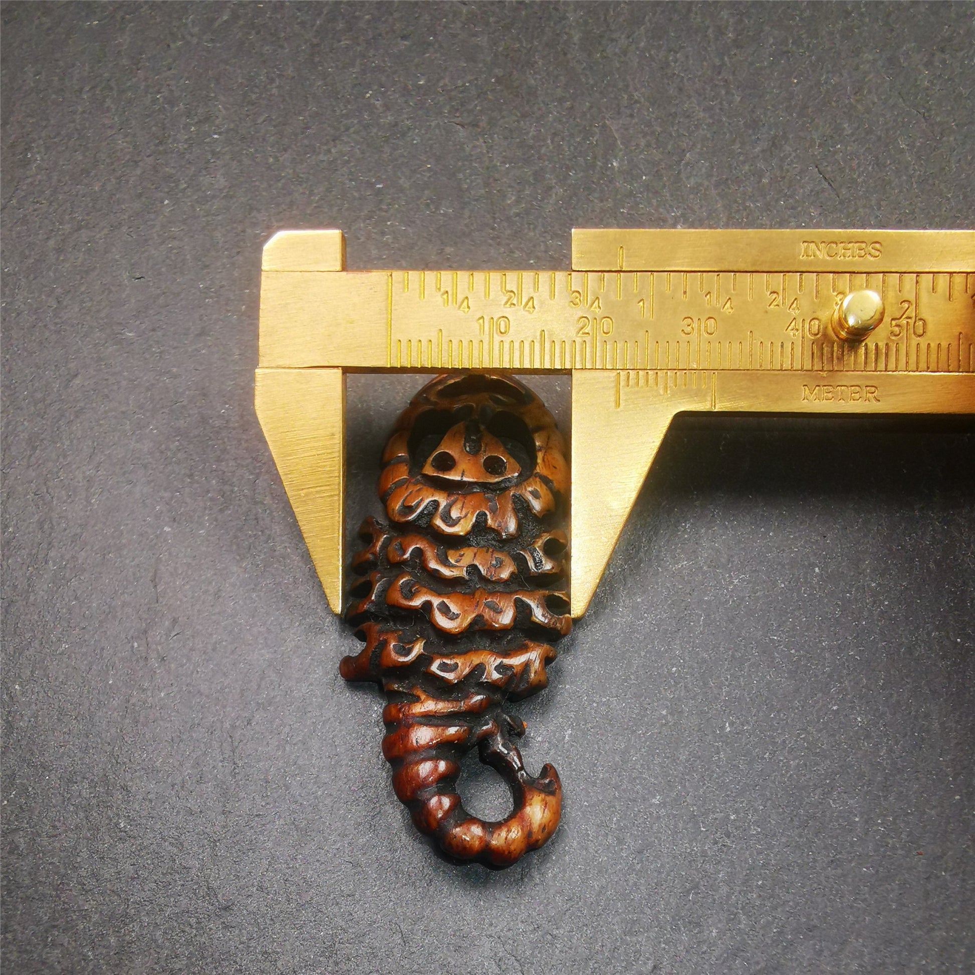 This unique bone carved Scorpion Guru pendant is made by Tibetan craftsmen in Hepo Township, Baiyu County, the birthplace of the famous Tibetan handicrafts. It's carved yak bone,brown color,2.2 inch height. You can make it into necklace,or mala pendant.