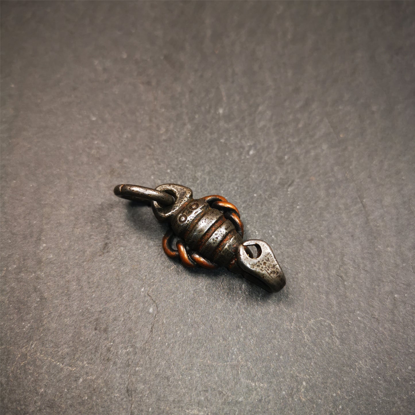 This scorpion amulet is made by Tibetan craftsmen in Hepo Township, Baiyu County, the birthplace of the famous Tibetan handicrafts. It is made of cold iron and copper,black color, size is 1.26 × 0.67 inches.The body is cold iron,and the legs are copper wire. You can make it into a necklace, or a keychain, or just put it in your shrine.