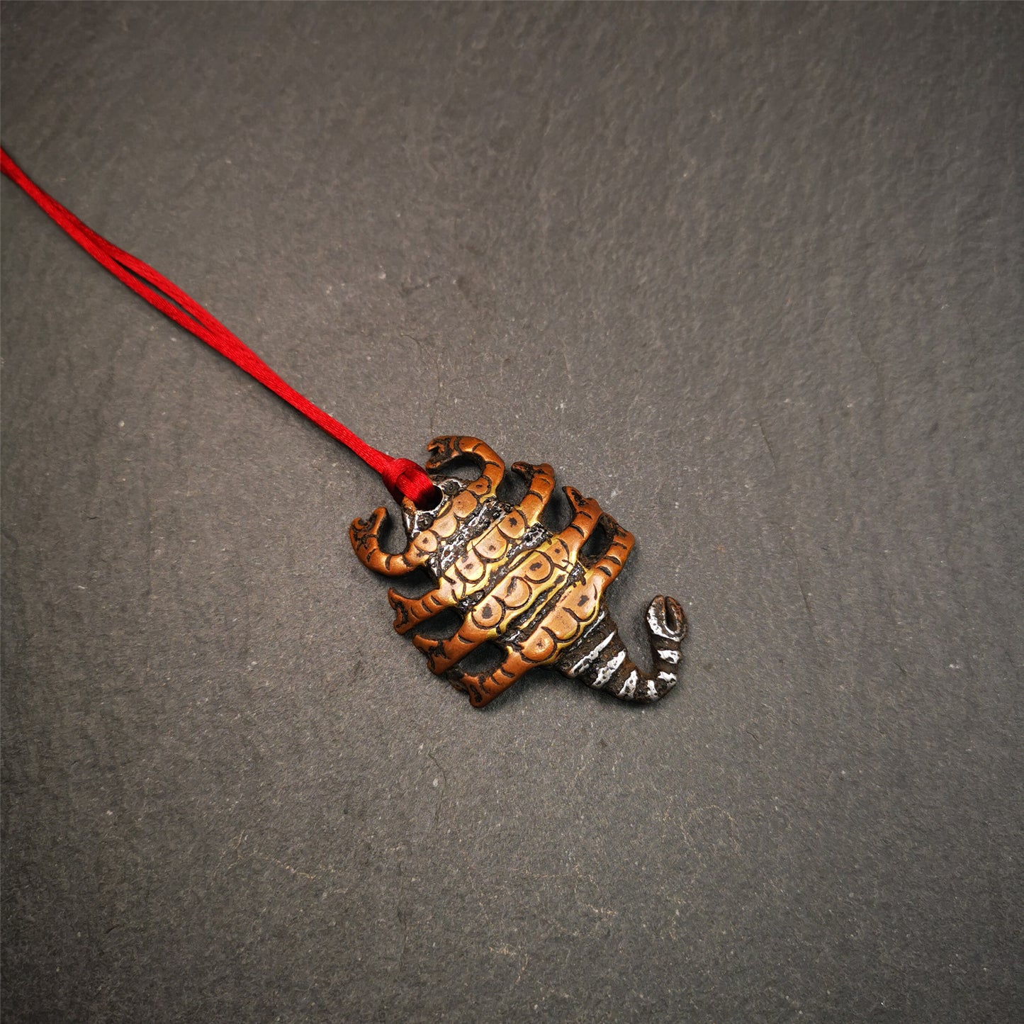 This scorpion amulet is made by Tibetan craftsmen in Hepo Township, Baiyu County, the birthplace of the famous Tibetan handicrafts. It is made of cold iron and copper,black color, size is 1.6 × 1.2 inches.The body is cold iron,and the legs are copper wire. You can make it into a necklace, or a keychain, or just put it in your shrine.