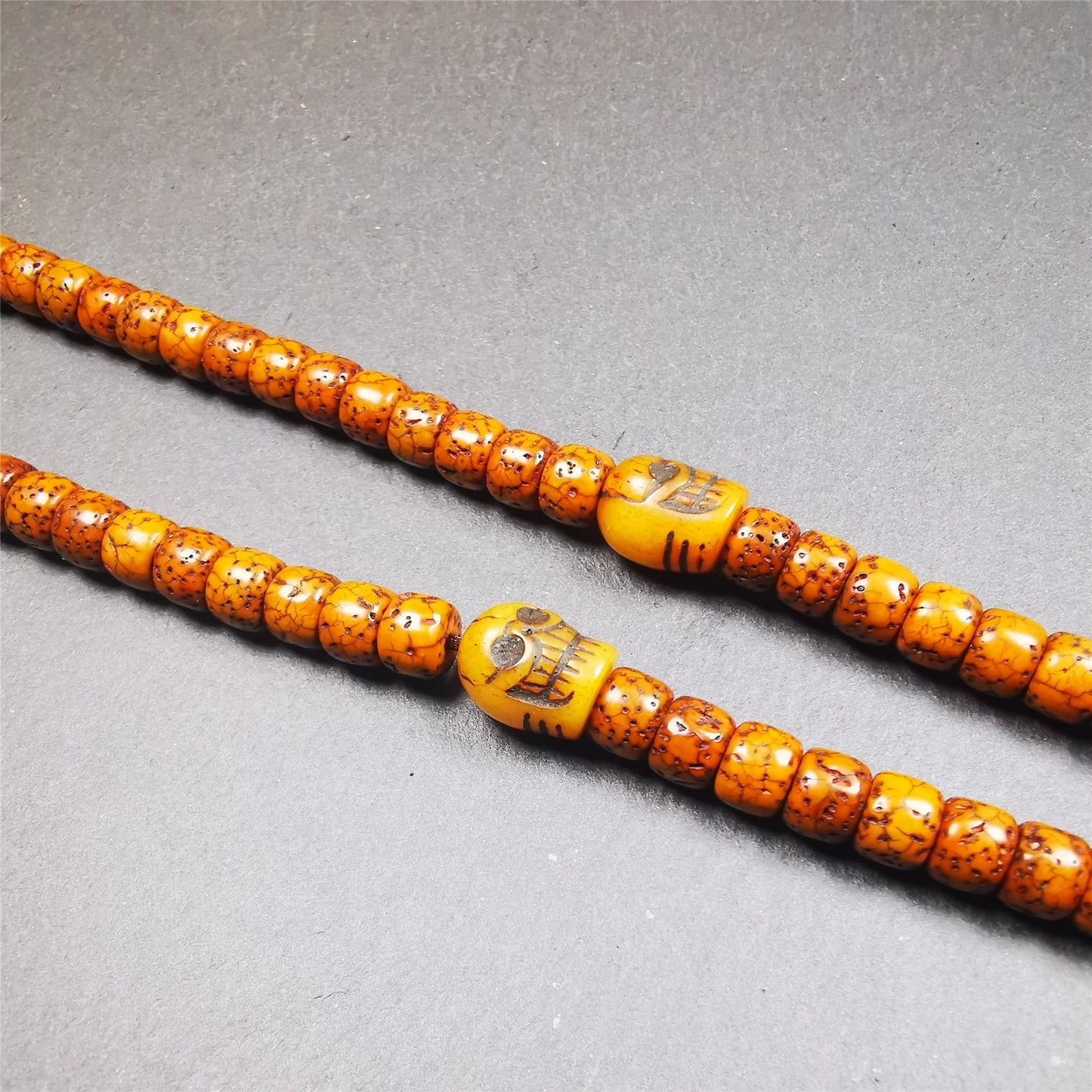 These marker beads were handmade by Tibetan craftsmen and come from Hepo Town, Baiyu County, the birthplace of the famous Tibetan handicrafts. It is made of yak bone,carved skull pattern,beige color,size is 0.4" × 0.5". Fit for 6-10mm mala (The reference in the photo is 7mm mala)
