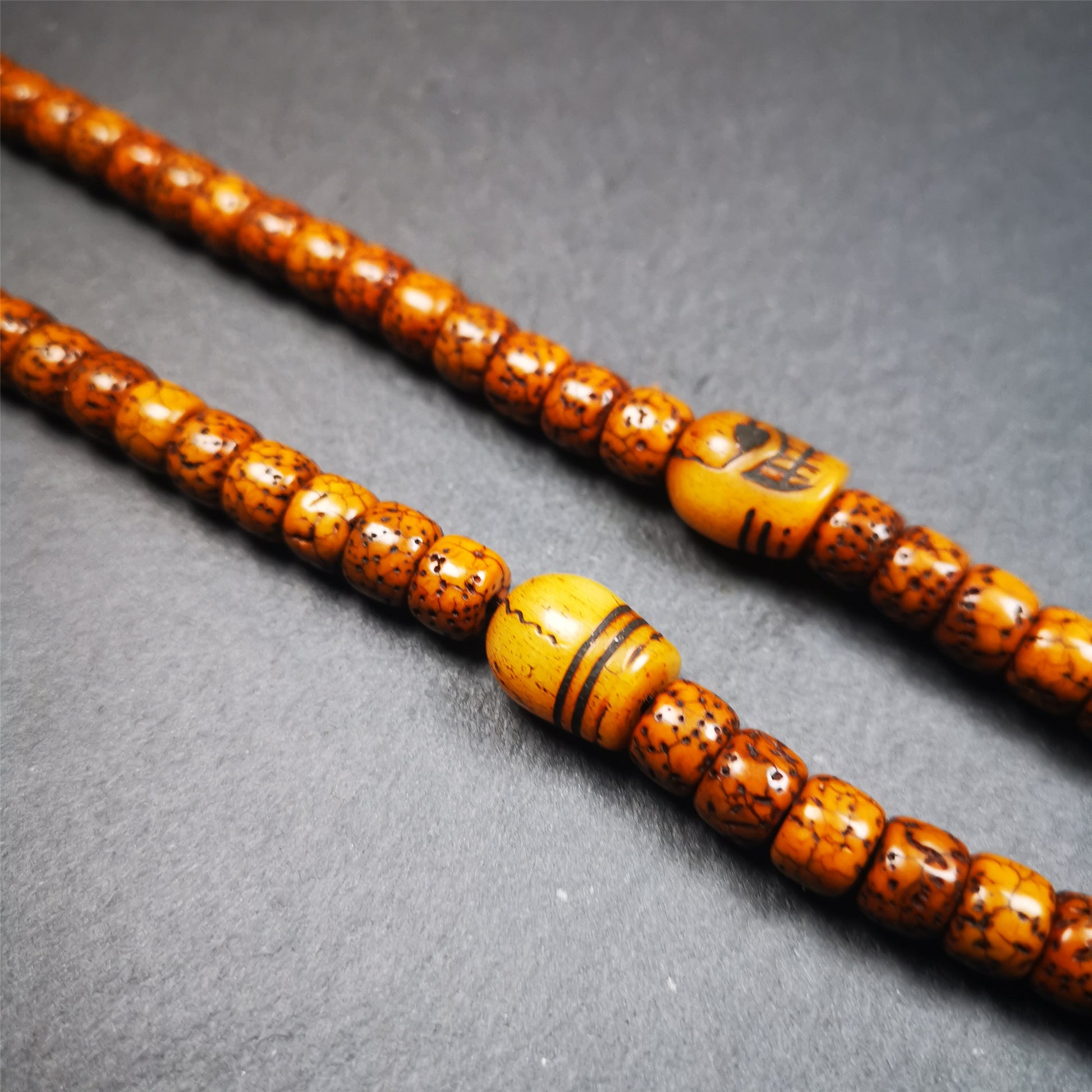 These marker beads were handmade by Tibetan craftsmen and come from Hepo Town, Baiyu County, the birthplace of the famous Tibetan handicrafts. It is made of yak bone,carved skull pattern,beige color,size is 0.4" × 0.5". Fit for 6-10mm mala (The reference in the photo is 7mm mala)