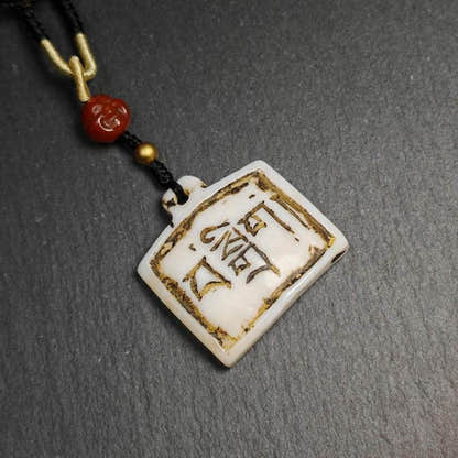 Amulet Badge with Tibetan Letters - Tibetan Buddhist amulet, close-up detail