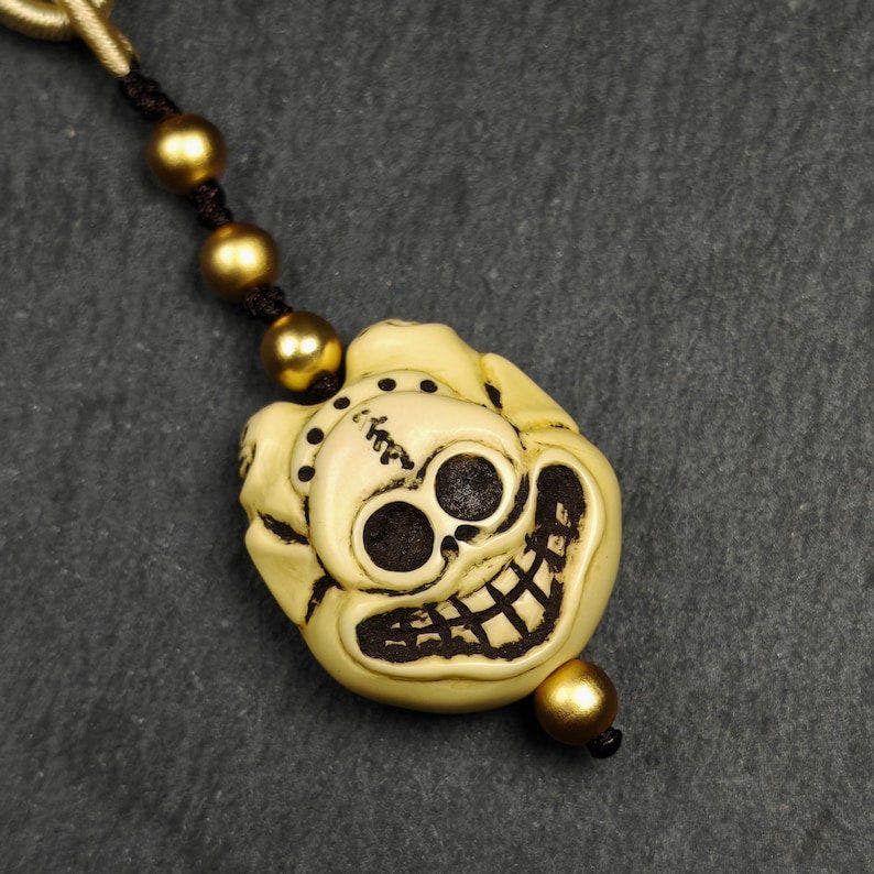 Tibetan Amulet,Citipati Skull Pendant,Made of Celluloid - Tibetan Buddhist amulet, detailed view