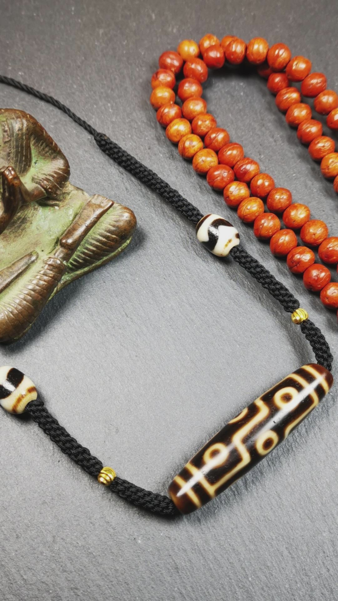 This necklace was hand-woven by Tibetans from Baiyu County, the main bead is a 9 eyed  dzi bead, paired with 2 small tiger tooth dzi beads,about 30 years old. It can be worn as a fashionable accessory,holds cultural and religious significance.