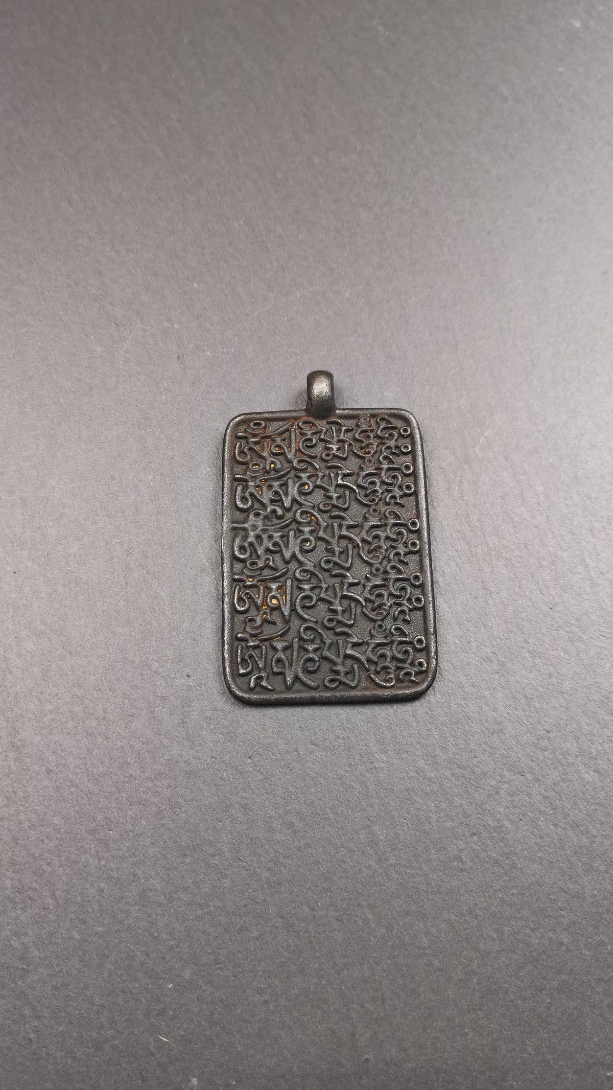 This badge is made by Tibetan craftsmen from Hepo Town, Baiyu County, the birthplace of the famous Tibetan handicrafts. It is made of copper, 2.52 × 1.57 inches. The front is the OM mantra and the back is body, speech, and mind.