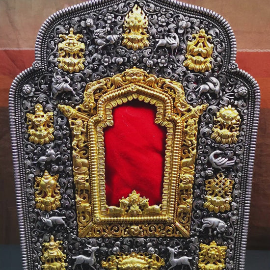 This large Gau shrine was handcrafted by Tibetan artisans from Hepo Township, Baiyu County. Each exquisite pattern on it is meticulously hand-carved,and it is embellished with the technique of gold inlay, with pure silver inlaid on the red copper material and gold-plated on the pure silver material.Its theme is Astamangala, and it features 10 mythical creatures traversing a silver-patterned meadow. The interior space of the box is quite spacious, large enough to accommodate a 12 * 8 cm Buddha statue.