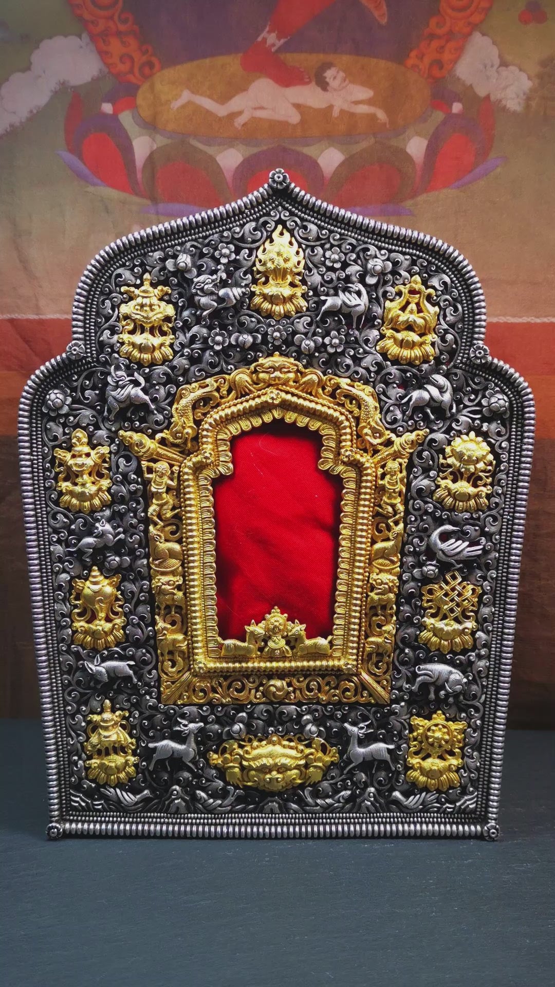 This large Gau shrine was handcrafted by Tibetan artisans from Hepo Township, Baiyu County. Each exquisite pattern on it is meticulously hand-carved,and it is embellished with the technique of gold inlay, with pure silver inlaid on the red copper material and gold-plated on the pure silver material.Its theme is Astamangala, and it features 10 mythical creatures traversing a silver-patterned meadow. The interior space of the box is quite spacious, large enough to accommodate a 12 * 8 cm Buddha statue.