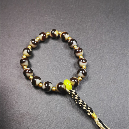 This tiger tooth dzi bracelet was hand-woven by Tibetans from Baiyu County,Tibet. It consists of 15 tiger tooth dzi beads and 15 spacer beads,tie with elastic cord to fit your wrist.  Dzi beads are precious jewelry from Tibetan culture which are believed to possess the power of bringing good fortune to the owners.  You'll get 1 dzi bracelet as pictures shown.
