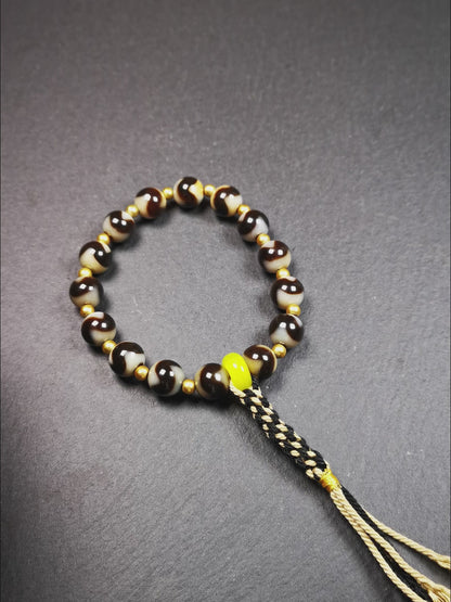 This tiger tooth dzi bracelet was hand-woven by Tibetans from Baiyu County,Tibet. It consists of 15 tiger tooth dzi beads and 15 spacer beads,tie with elastic cord to fit your wrist.  Dzi beads are precious jewelry from Tibetan culture which are believed to possess the power of bringing good fortune to the owners.  You'll get 1 dzi bracelet as pictures shown.