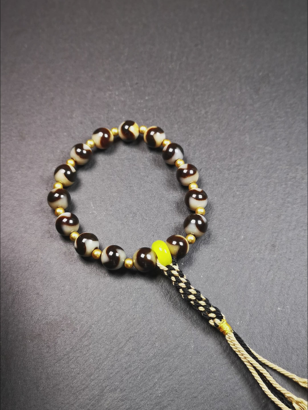 This tiger tooth dzi bracelet was hand-woven by Tibetans from Baiyu County,Tibet. It consists of 15 tiger tooth dzi beads and 15 spacer beads,tie with elastic cord to fit your wrist.  Dzi beads are precious jewelry from Tibetan culture which are believed to possess the power of bringing good fortune to the owners.  You'll get 1 dzi bracelet as pictures shown.