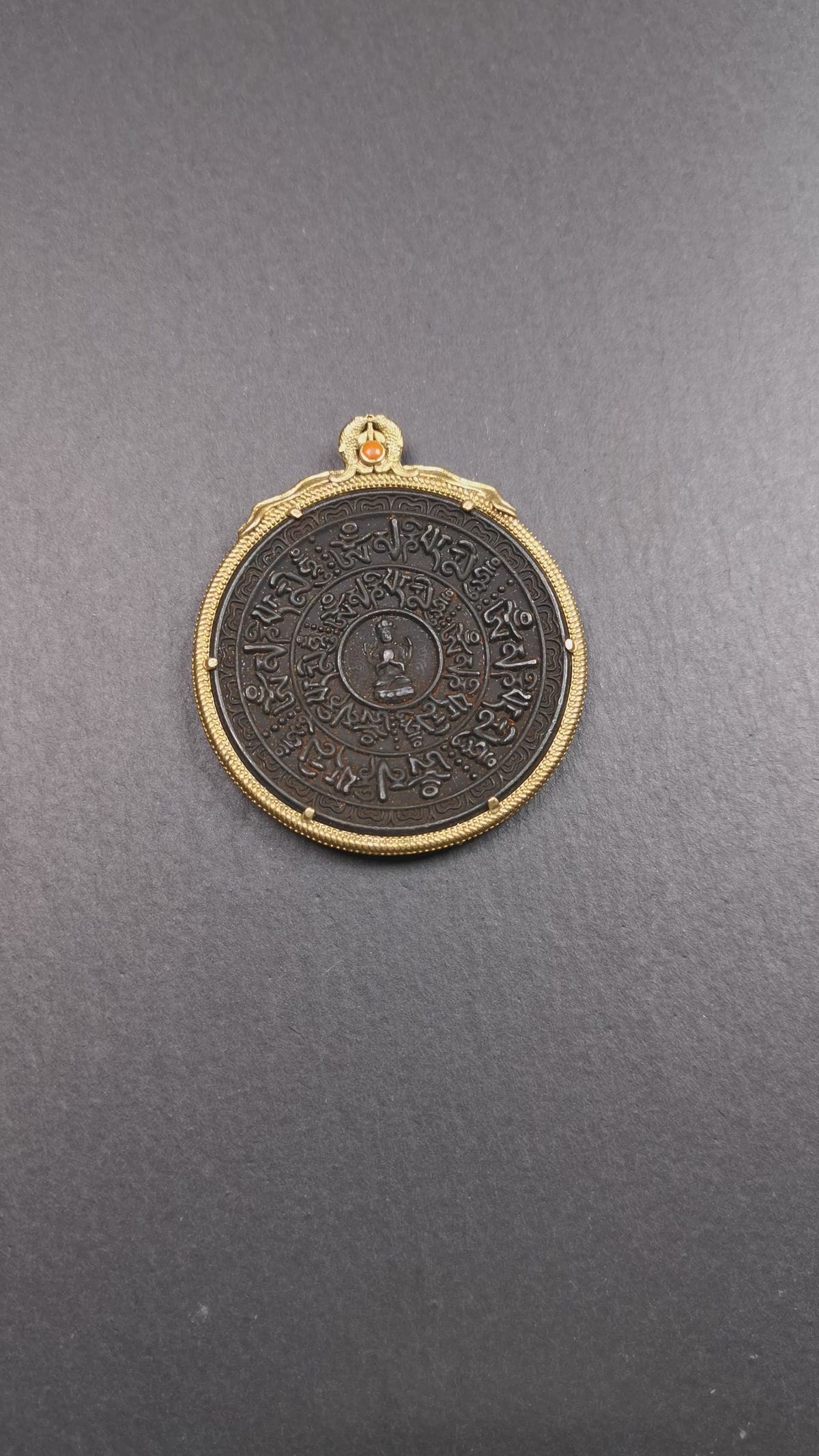 This badge was made by Tibetan craftsmen and come from Hepo Town, Baiyu County,Tibet. It is made of thokcha, edging with copper, 2.1 diameter. The mantra Om Mani Padme Hum is arranged in concentric circles around the chenrezig.
