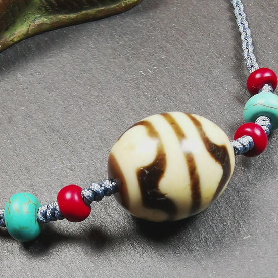 This necklace was hand-woven by Tibetans from Baiyu County, the main bead is a lotus dalo dzi bead, paired with turquoise and agate beads,about 40 years old. It can be worn not only as a fashionable accessory but also holds cultural and religious significance. The length of the necklace can be adjusted, the maximum circumference is about 60cm.