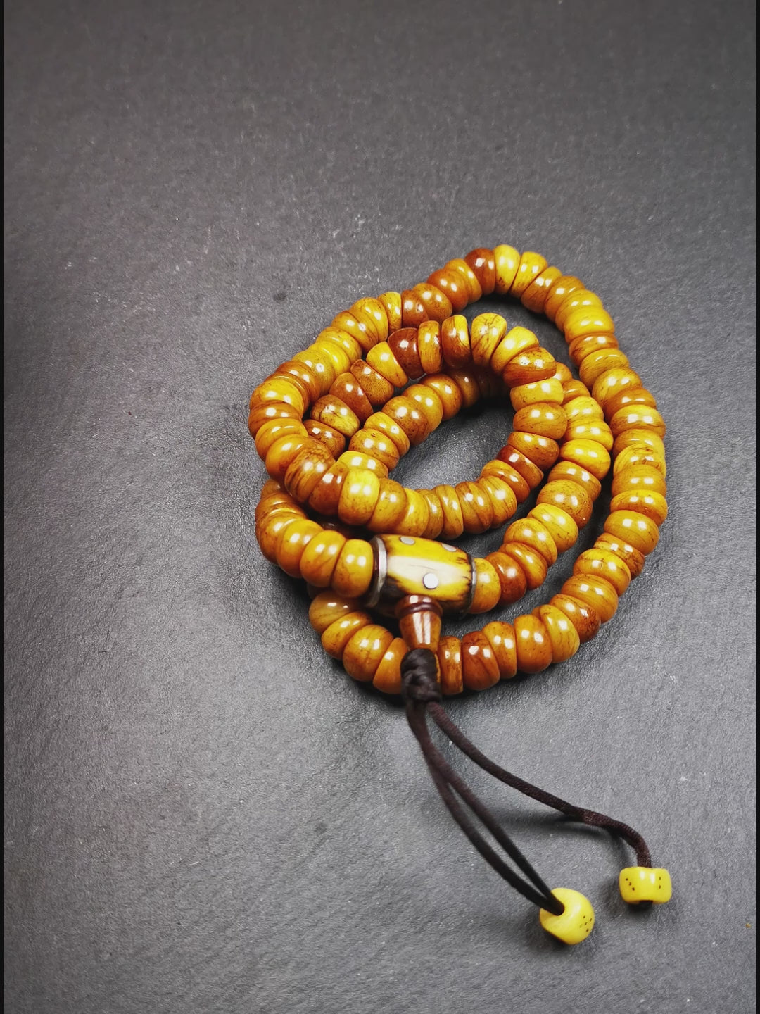 This mala was made by Tibetan craftsmen,about 30 years old.  It is made of yak bone, yellow color,108 bevel cut beads diameter of 10mm / 0.4 inch,circumference is 50cm / 20 inches,1 guru bead and 2 dice pendant beads.
