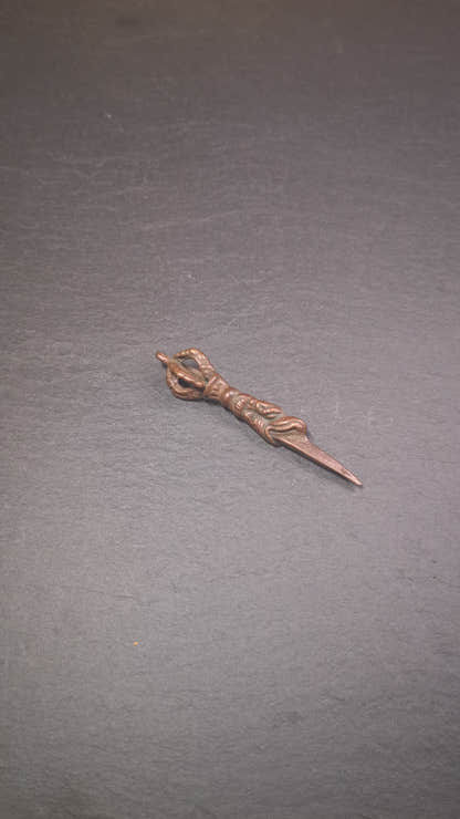 This vintage Phurba pendant was collected from gengqing Monastery(Derge,Tibet),handmade of copper. It is total 2.6 inches,brown color,on top of it is a dragon, the tail of the dragon is half vajra, from the dragon's mouth comes a phurba.