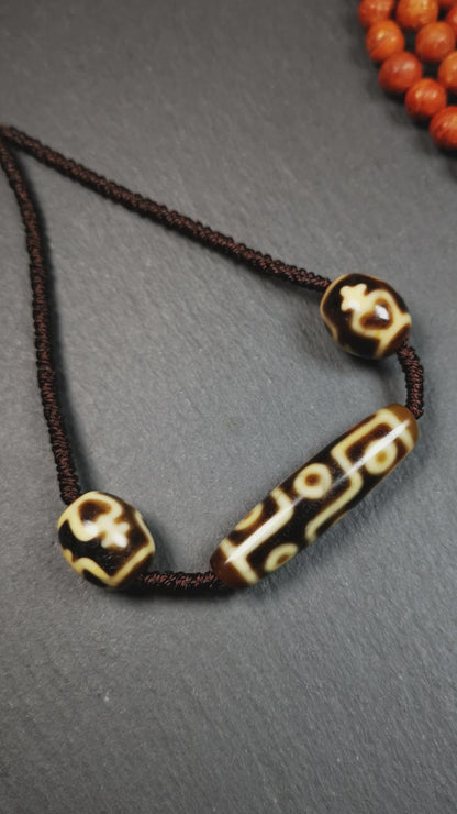 This necklace was hand-woven by Tibetans from Baiyu County, the main bead is a 9-eye dzi, paired with 2 treasure vase dalo dzi beads,about 30 years old. It can be worn not only as a fashionable accessory but also holds cultural and religious significance.