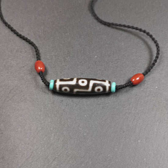 This 9 eyes dzi necklace was hand-woven by Tibetans from Baiyu County, the main bead is a 9 eyed  dzi bead, paired with 2 small agate beads and 2 turquoise spacer beads,about 30 years old.