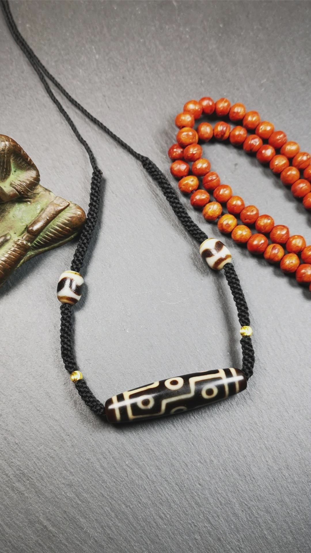 This necklace was hand-woven by Tibetans from Baiyu County, the main bead is a 9 eyed  dzi bead, paired with 2 small tiger tooth dzi beads,about 30 years old. It can be worn as a fashionable accessory,holds cultural and religious significance.